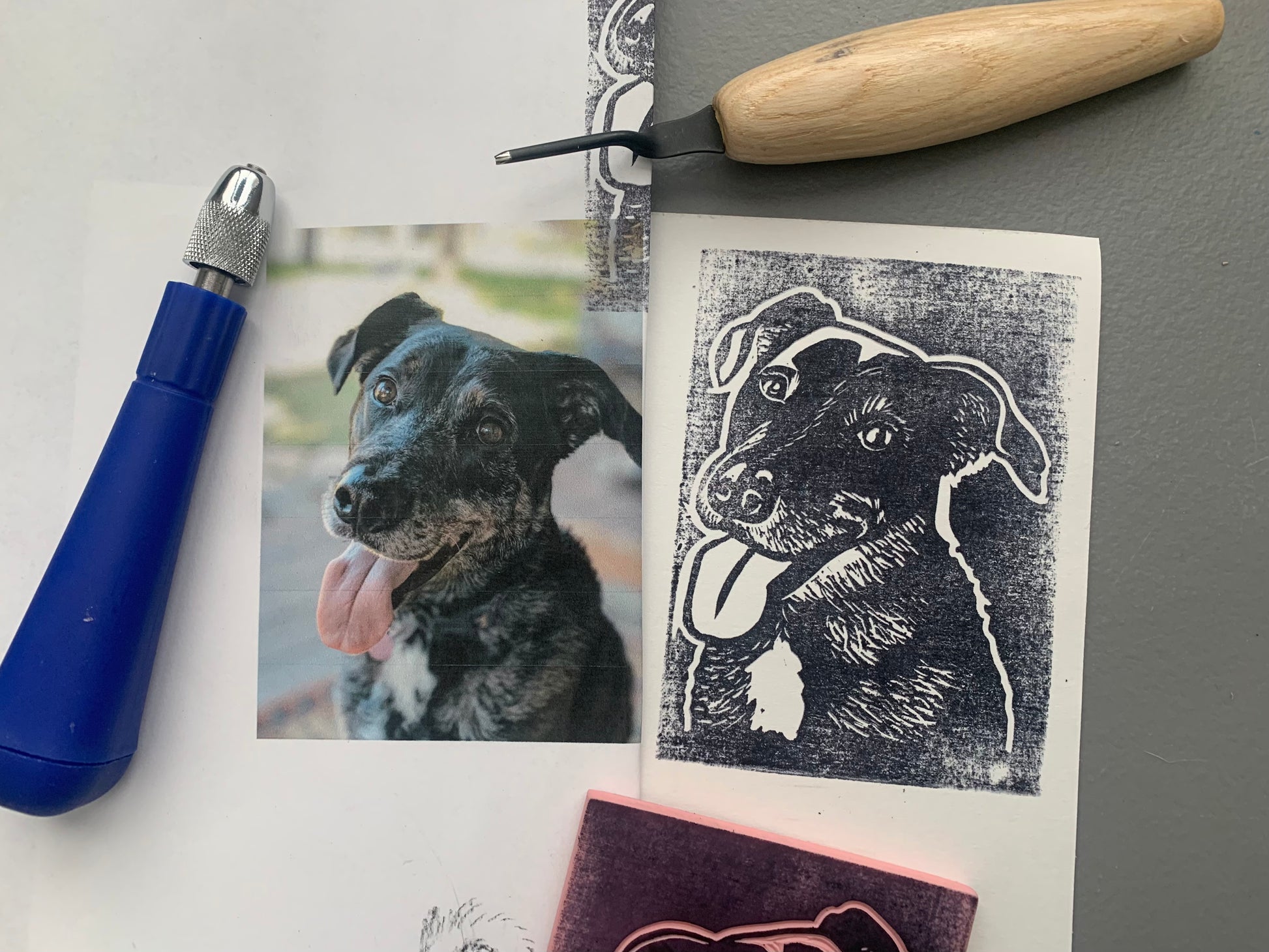 photo of a dog next to a printed stamp of the same dog, surrounded by carving tools